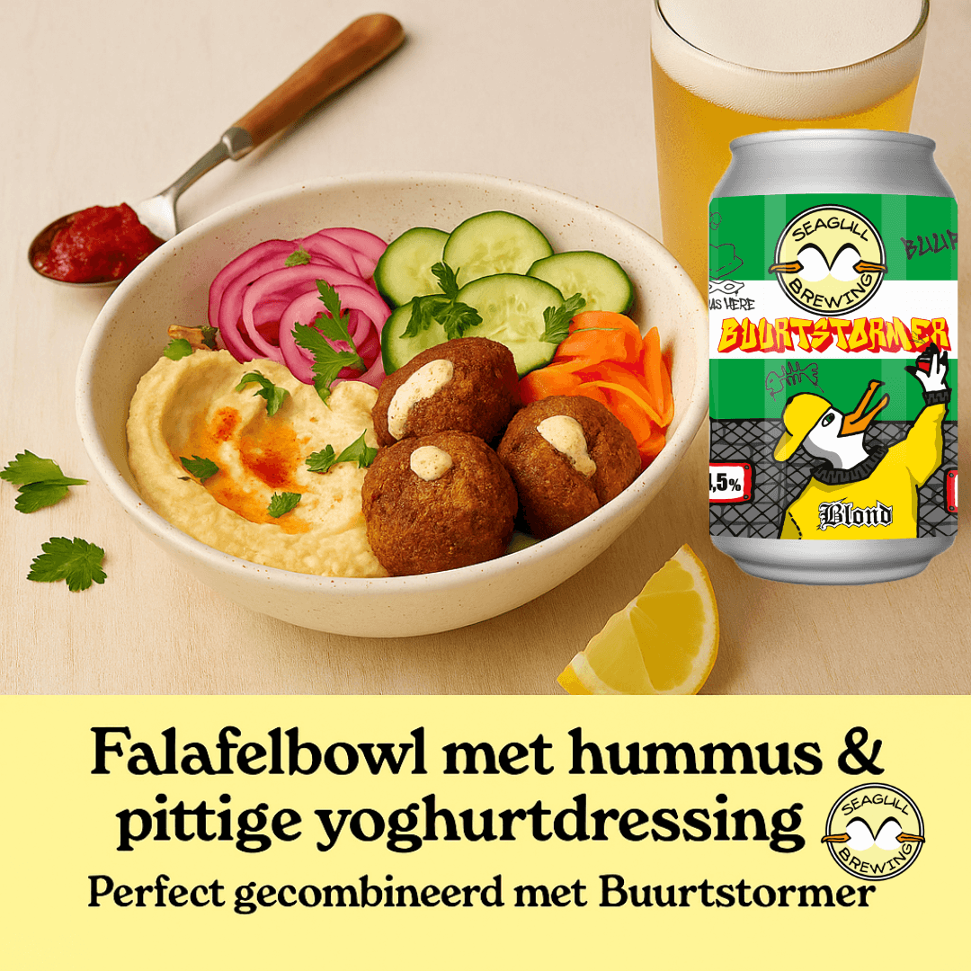 Een kleurrijke falafelbowl met hummus, ingelegde groenten en yoghurtdressing, geserveerd met een glas Buurtstormer van Seagull Brewing.